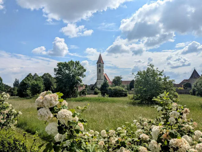 Bad Radkersburg town fortifications with moat in the foreground and parish church.