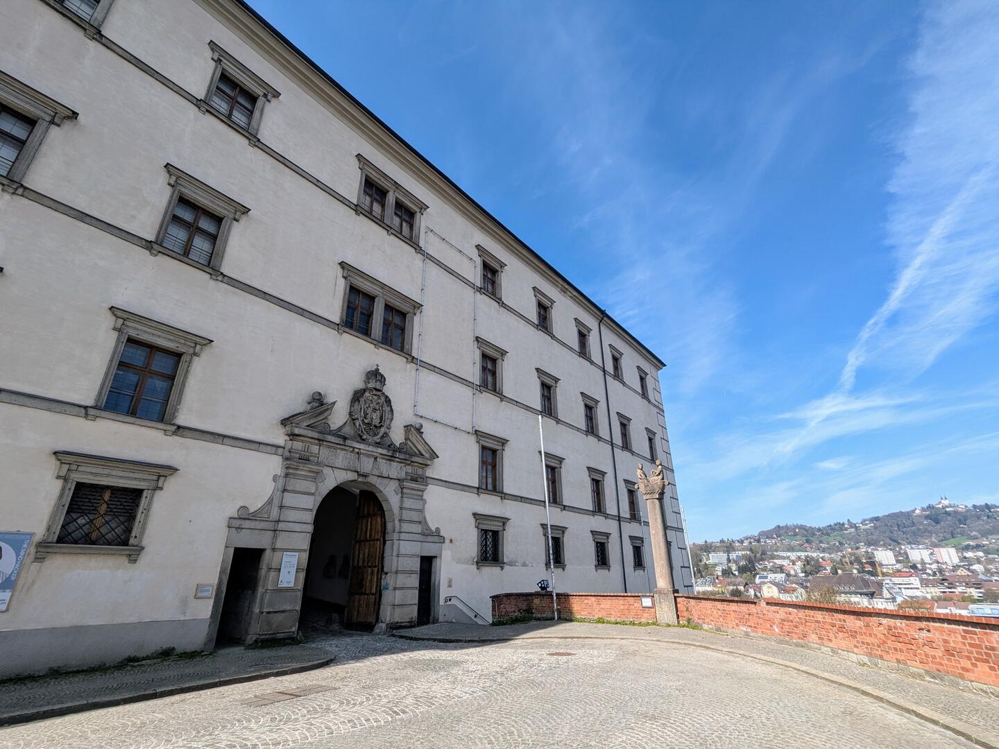 Eingangstor Linzer Schloss über Altstadt von Linz mit Ausblick auf Donau und Pöstlingberg.