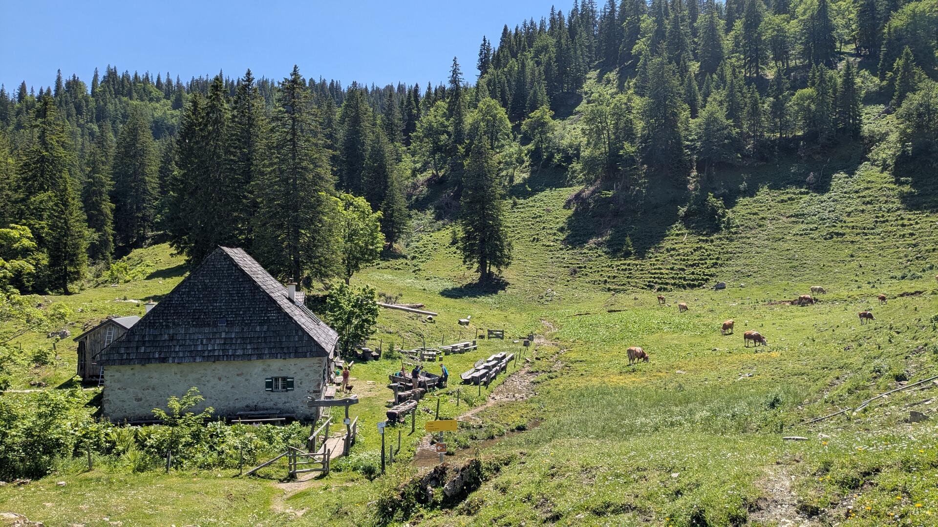 Hütte Herrenalm. Eine Gruppe von Wanderern macht sich gerade auf, ihren Weg fortzusetzen.