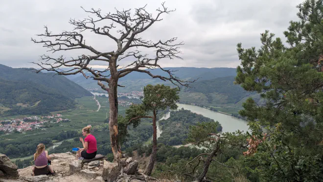 Dürnsteiner Kanzel mit Blick über Donau und Rossatz. Zwei Wanderinnen legen eine Rast ein.